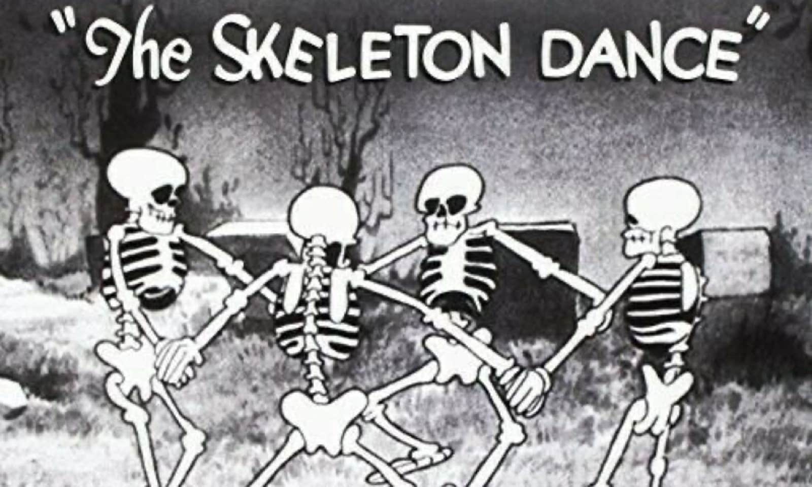 A still image from the Walt Disney Silly Symphony 'The Skeleton Dance' showing four skeletons dancing in a graveyard.